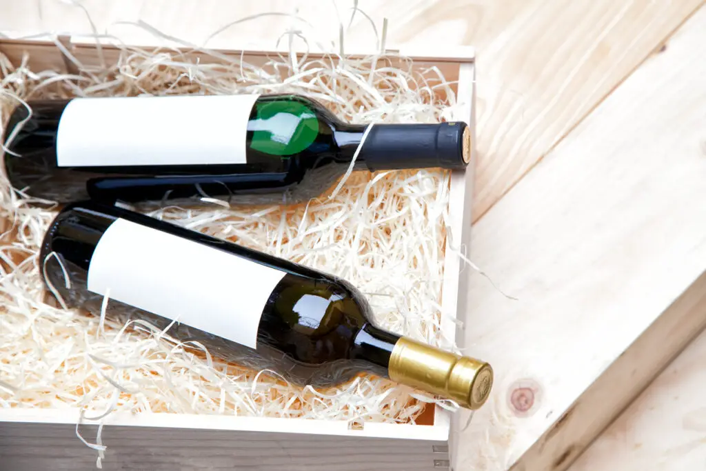 bottles of wine in a wooden box on a wooden background