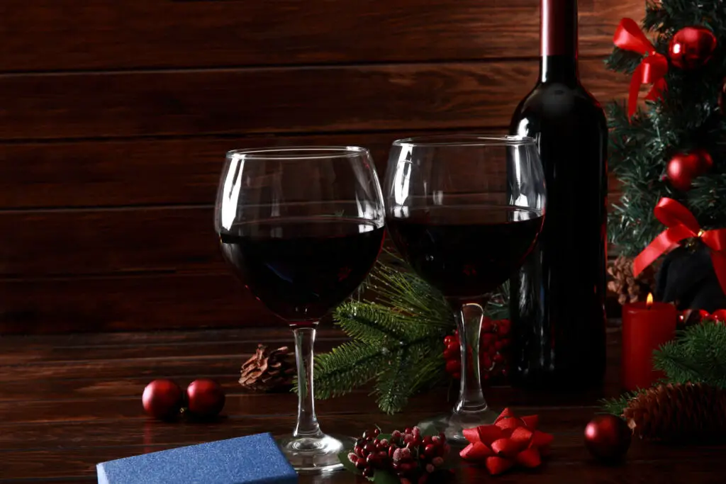 Glasses of Red Wine and bottle surrounded by Christmas Decoration