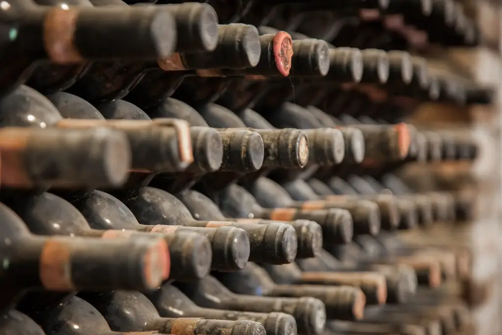 old wine bottles covered with dust and cobwebs are in the wine cellar