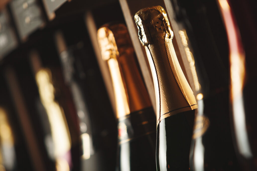 Bottles of champagne on the shelf, close-up image of alcoholic beverages in the wine cellar. Close-up image.