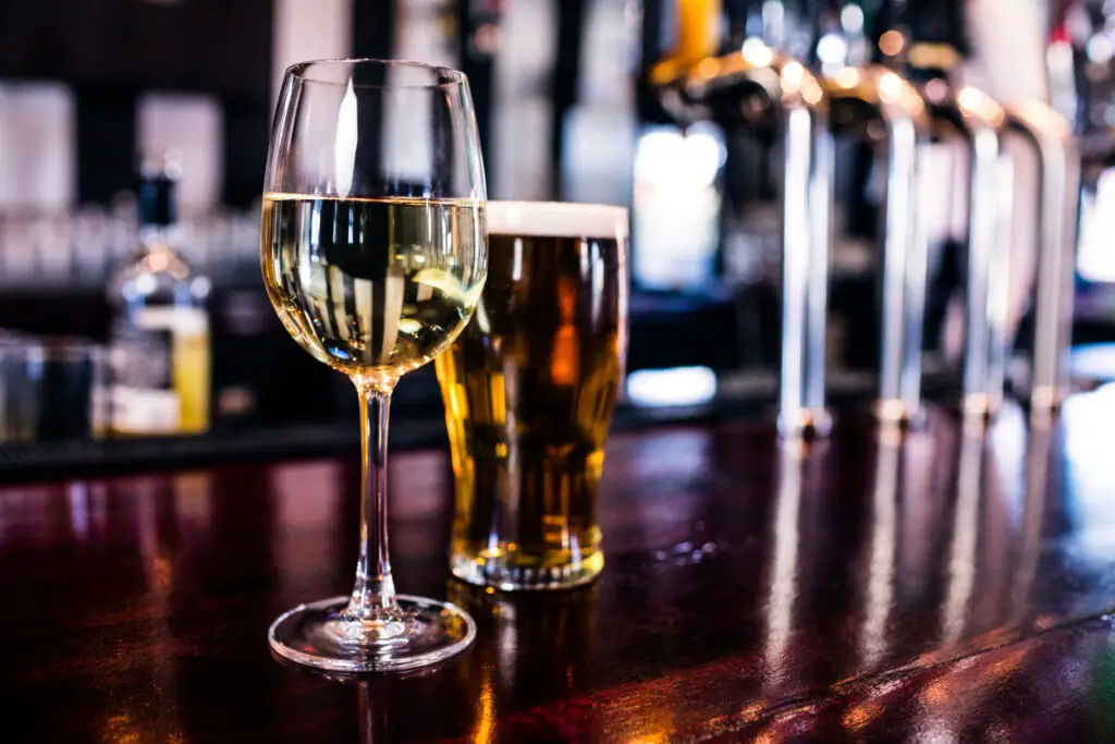 Close up of a glass of wine and a beer