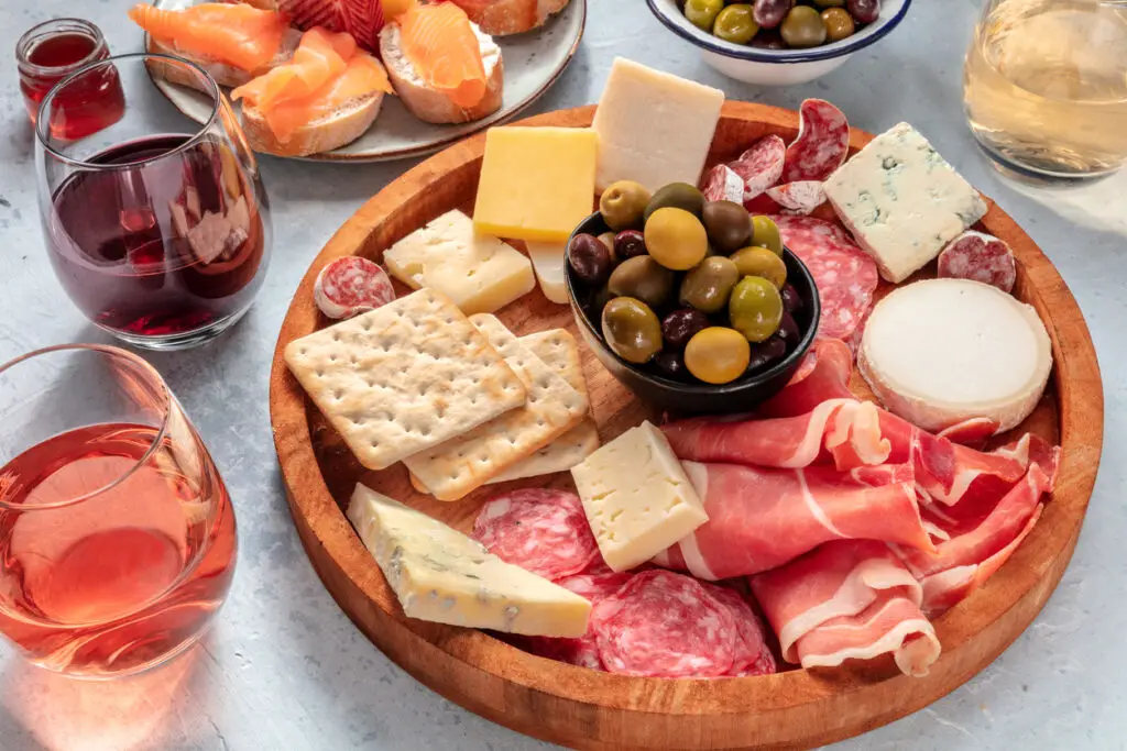 Charcuterie and cheese board with wine and olives. Italian antipasti