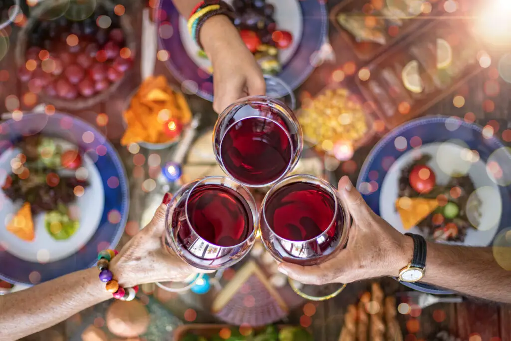 Family dinner for a celebration with red wine and cheers.