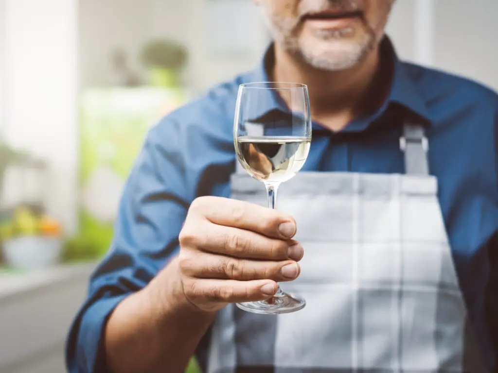 Man having a glass of wine in the kitchen