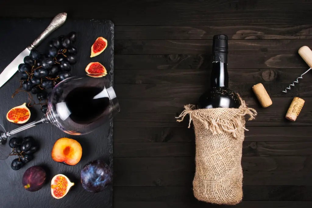 Food background with red wine, figs, grapes and cheese