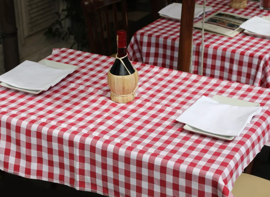 red and white checkered tablecloths with a flask bottle of wine in the Italian trattoria