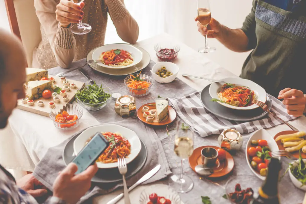 Friends having a pasta dinner at home or at a restaurant