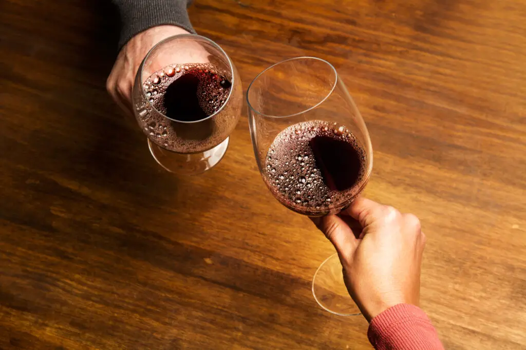 Man and woman toasting with red wine