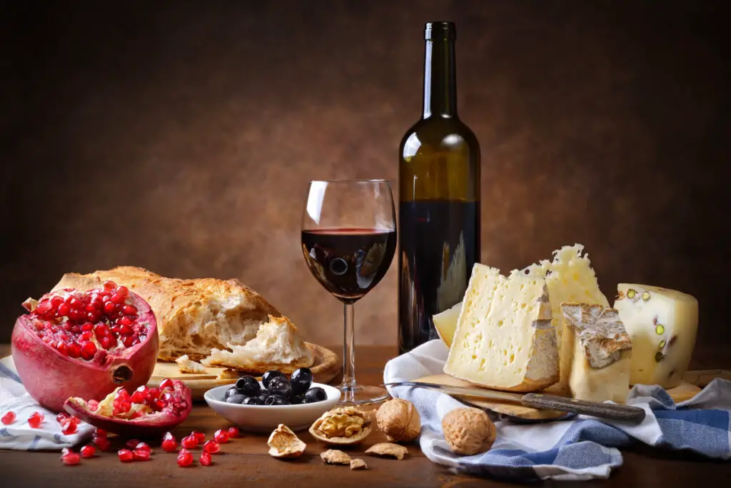 Red wine, cheese, walnuts, olives, pomegranate and bread.