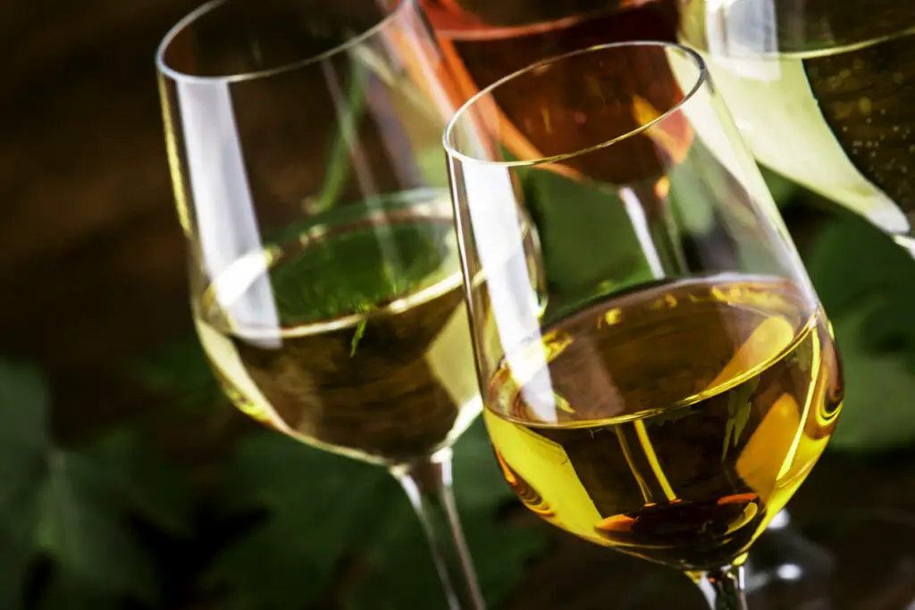 White wine set. Wine tasting, the most popular varieties of white wines in wine glasses on vintage wooden table in rustic style, selective focus