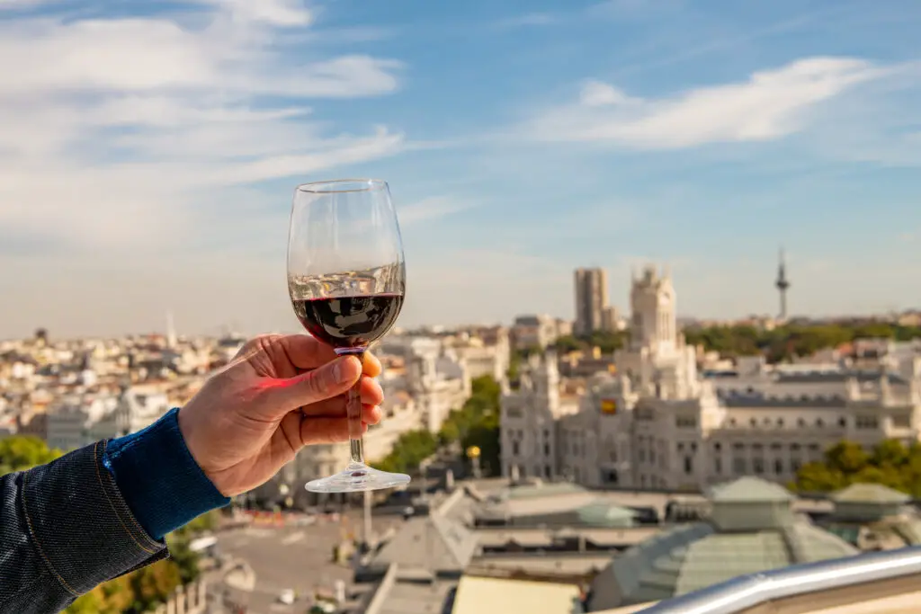 A glass of red wine held up for a toast in Madrid, Spain.