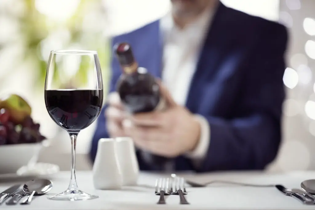 Businessman reading a wine bottle label in restaurant