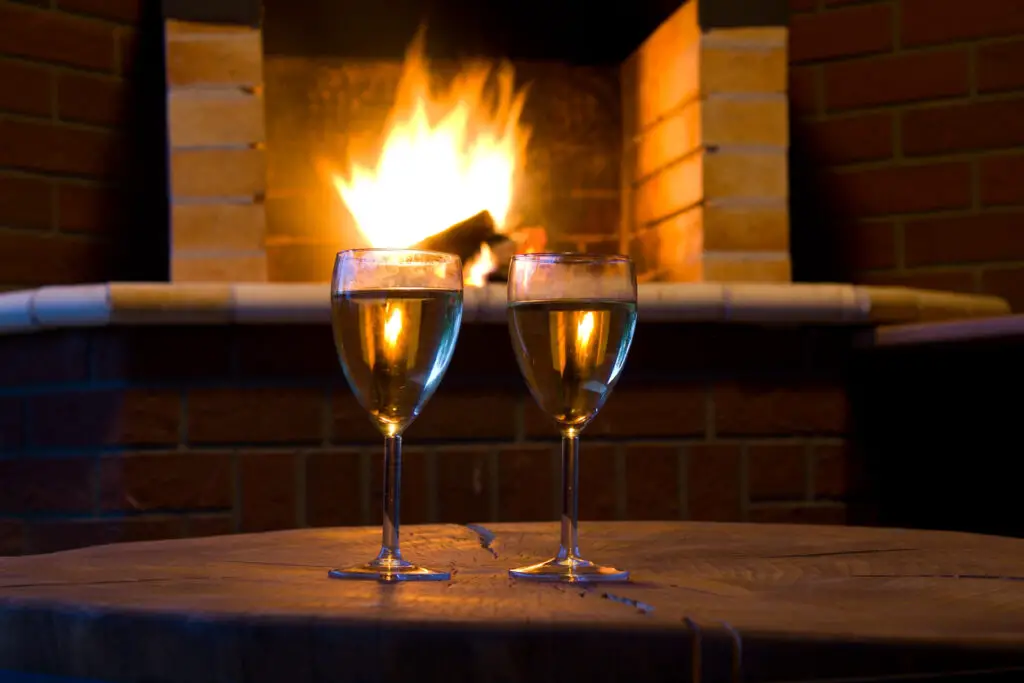 Glasses of wine in front of a fireplace