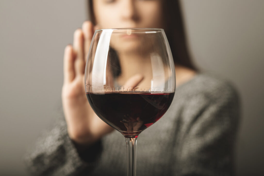 reject liquor,stop alcohol, teenager girl shows a sign of refusal of wine
