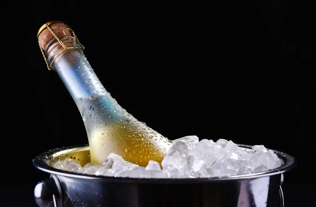 Bottle of sparkiling wine in bucket with crushed ice
