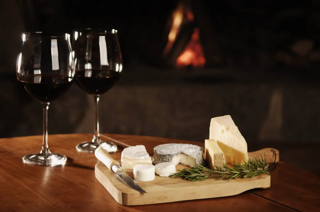red wine and cheese at fireplace